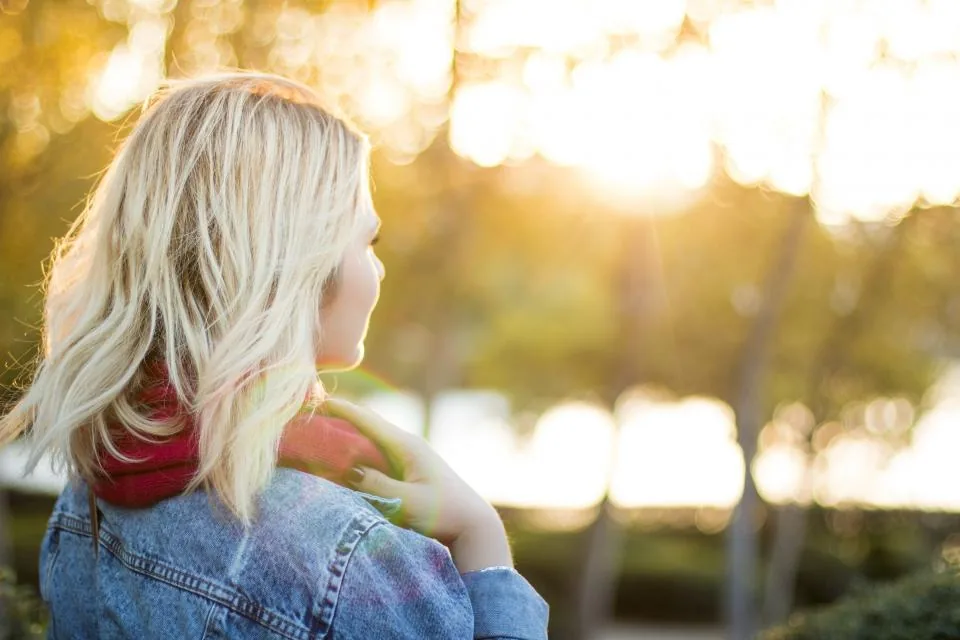 A young woman looking out toward warm morning light